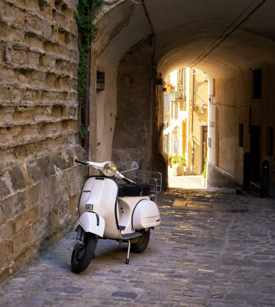 Italian motor scooter parked a dark alley.